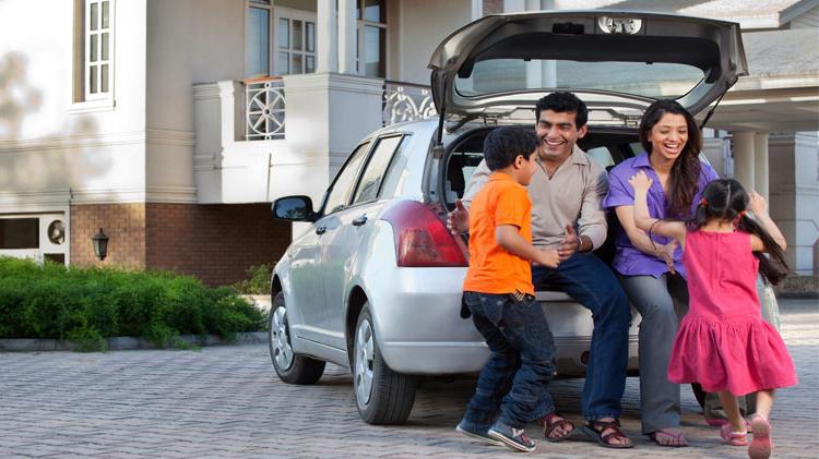 Family of four sitting on the back of their van.