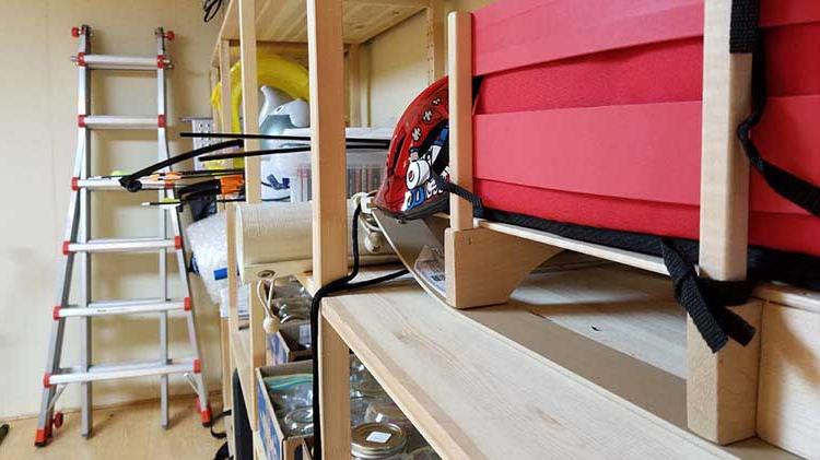 Basement showing items stored on shelves and items leaning against walls.